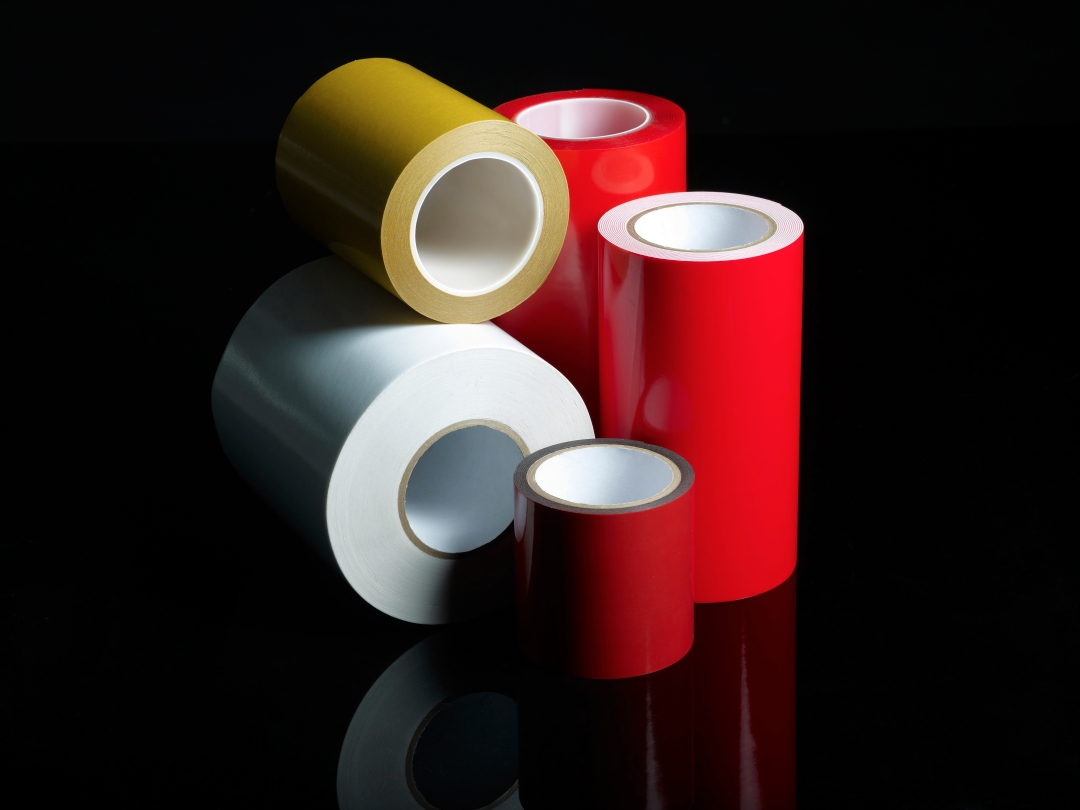Double-sided and single-sided adhesive tape rolls in red, yellow and white