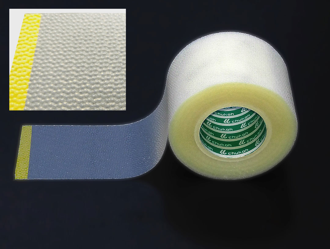 Transparent film tape unwound from its roll with a magnified view of its embossed surface texture