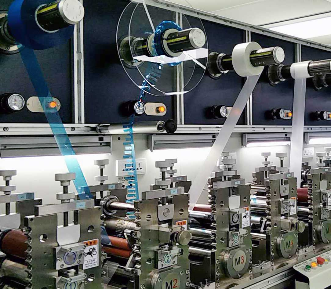 Multi-station rotary converting line running blue and clear liner webs